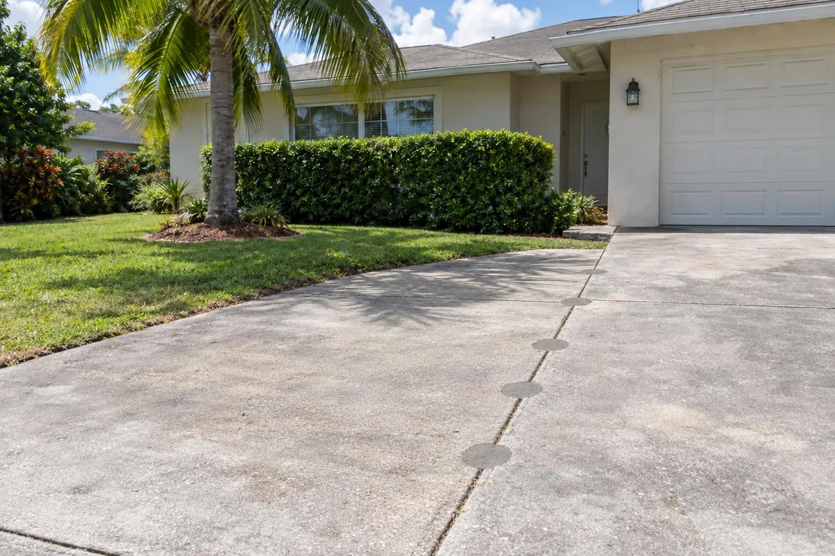 A level concrete driveway leading to a garage, flush at the seams